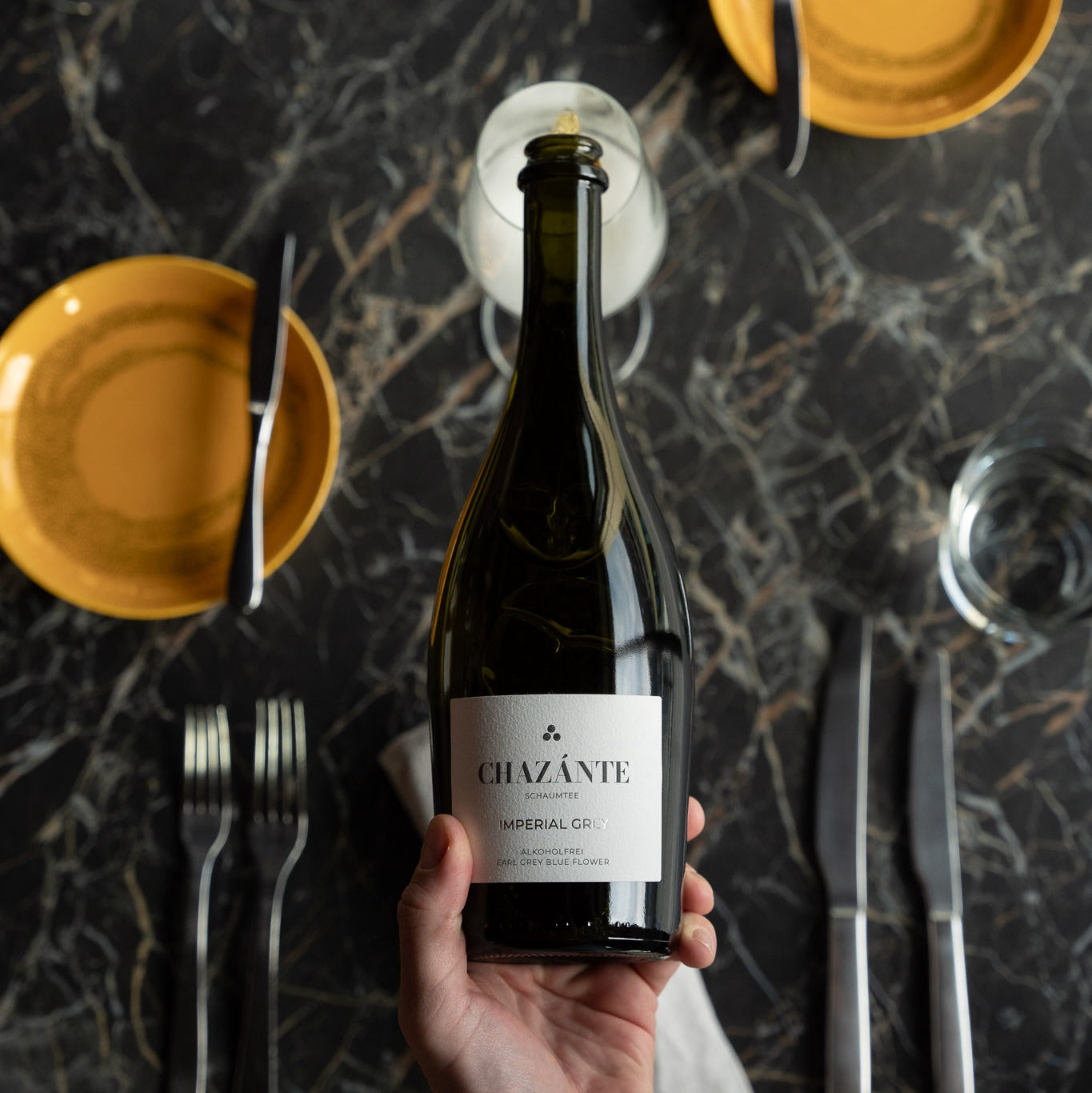 Einschenken spritziger, alkoholfreier Imperial Grey über elegant gedecktem Tisch
