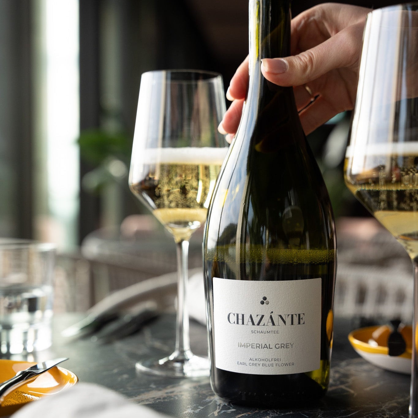 Flasche Chazánte alkoholfreie Sektalternative neben gefülltem Glas