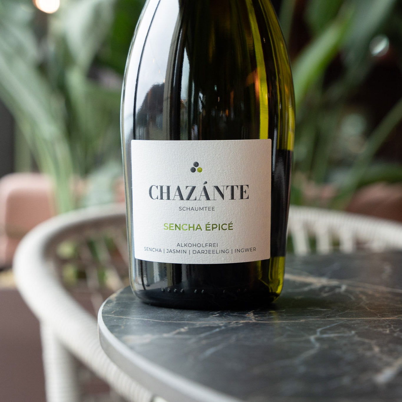 Alkoholfreie Weinalternative mit Sencha und würzigem Ingwer, Limonengras auf Tisch