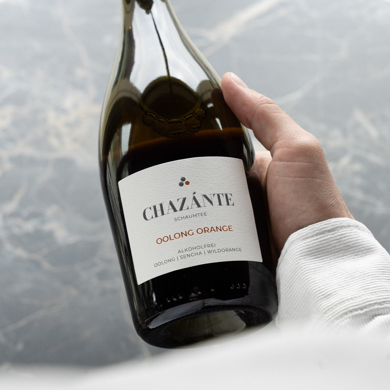 Elegante Flasche alkoholfreier Oolong Orange in Hand